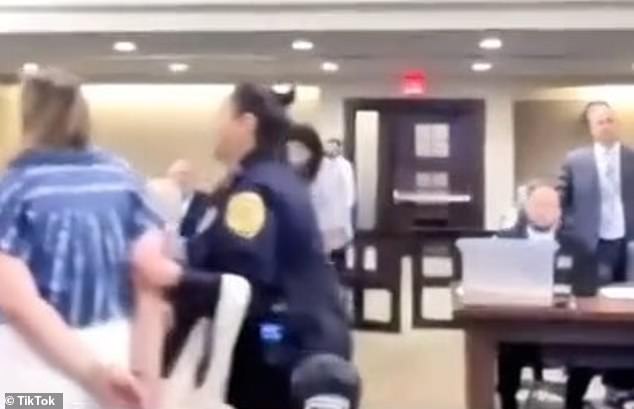 The officer then placed the woman in handcuffs and marched her out of the courtroom