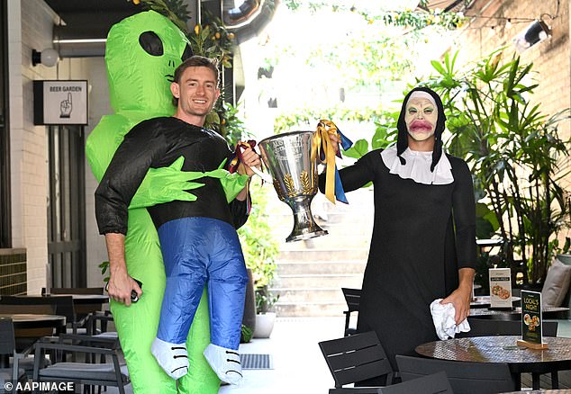 Harris Andrews (left) and Cam Rayner (right) celebrate the team's Mad Monday with the 2024 AFL Premiership Cup