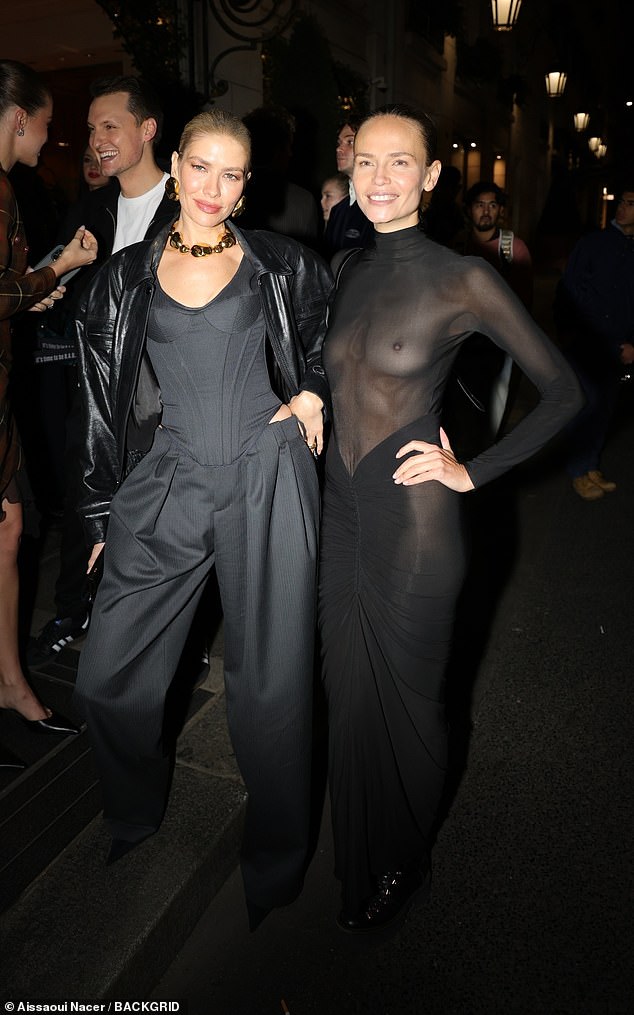 Elsewhere, Natasha Poly [R] dared to bare herself as she went braless under a sheer black dress as she arrived for the party