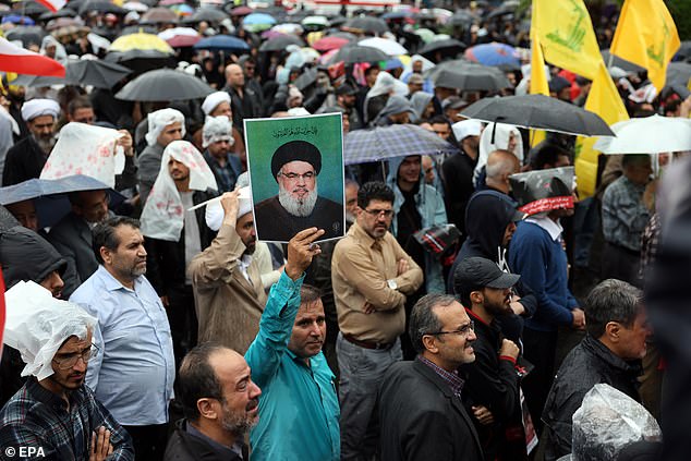 A protester holds a photo of late Hezbollah leader Hassan Nasrallah during an anti-Israel protest in Palestine Square in Tehran, Iran, September 28, 2024