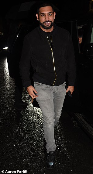 Ex-boxing champion Amir cuts a trendy figure in gray denim jeans and a black hoodie, paired with Louis Vuitton sneakers