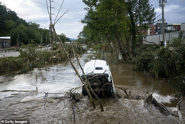 The once picturesque town is now in ruins. Cars line tree branches along the flooded Swannanoa River