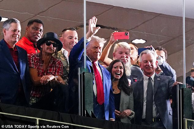 GOP presidential candidate Donald Trump waves flanked by former Georgia Bulldogs player Herschel Walker, recording artist Kid Rock, professional golfer John Daily, Alabama Senators Tommy Tuberville (R) and Katie Britt (R) during the second half of the game between the Alabama Crimson Tide and the Georgia Bulldogs at Bryant-Denny Stadium