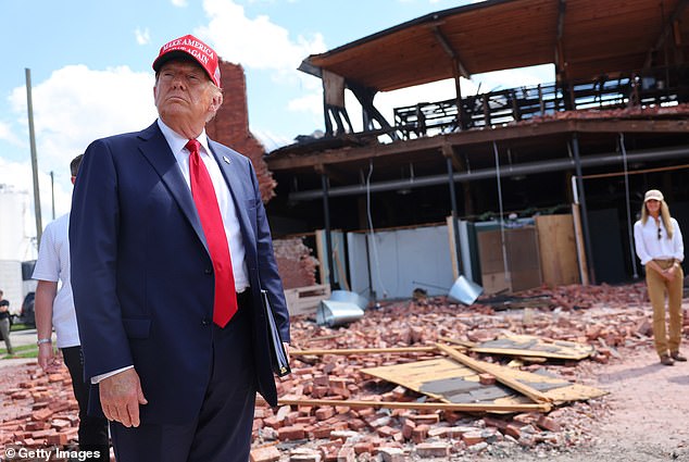 Republican presidential candidate, former US President Donald Trump, listens to a question while visiting Chez What Furniture Store, which was damaged during Hurricane Helene