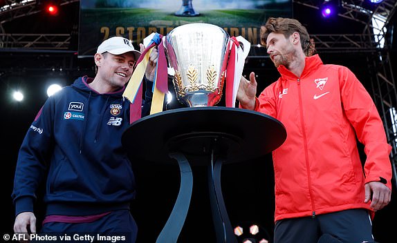 MELBOURNE, AUSTRALIA – SEPTEMBER 27: Lachie Neale of the Lions is the last to touch the cup as Dane Rampe of the Swans looks on during the 2024 AFL Grand Final Parade on September 27, 2024 in Melbourne, Australia. (Photo by Michael Willson/AFL Photos via Getty Images)