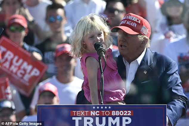 Trump holds his granddaughter Carolina at the microphone during the rally