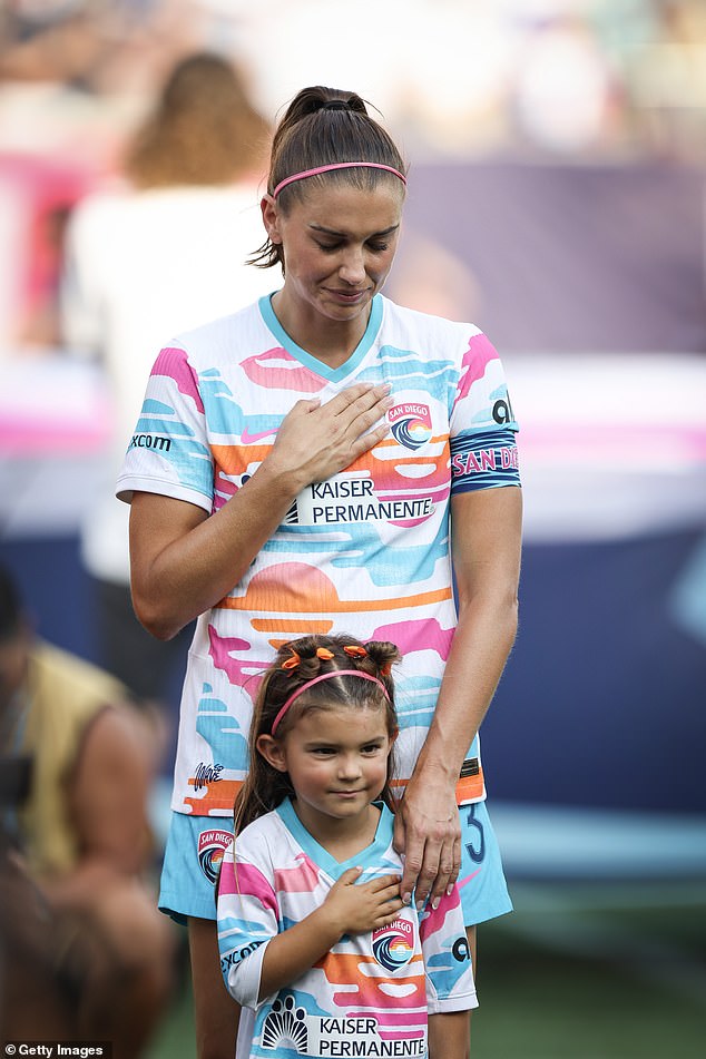 Alex Morgan stood next to her daughter Charlie during the final match of her professional career