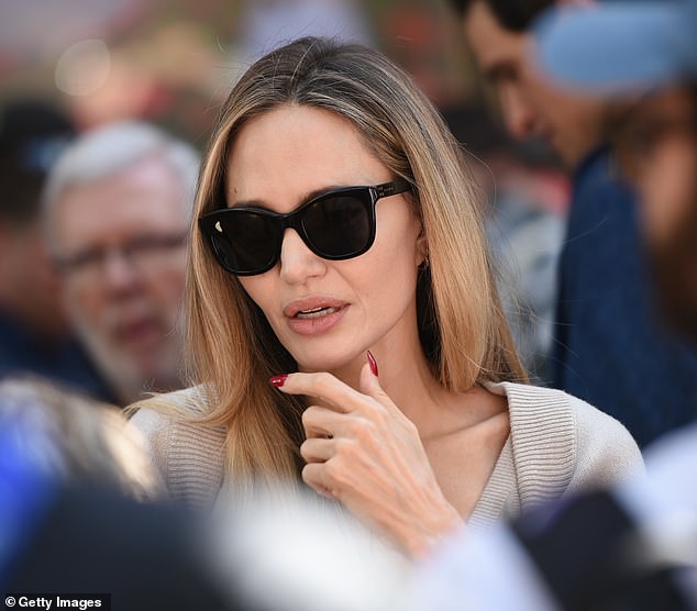 The Tomb Raider star dazzled in a flowing gray long-sleeved dress at the event, after flying back from Italy, where she attended the Venice Film Festival