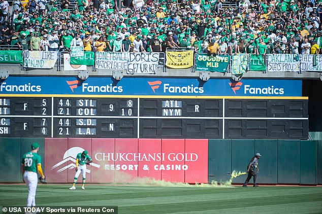 Athletics outfielder Lawrence Butler (4) reacts to smoke bombs being thrown onto the field