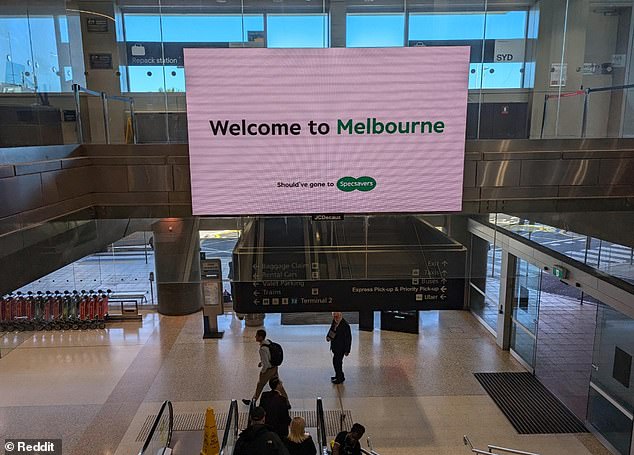 The Specsavers advert welcomed travellers to Sydney Airport in an arrivals lounge with a large LED screen reading 'Welcome to Melbourne' (pictured)