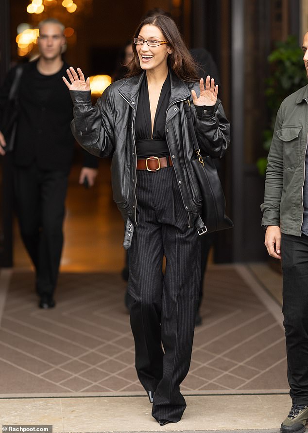 Bella Hadid waved to waiting fans as she made a stylish exit from her Paris hotel during Fashion Week on Tuesday