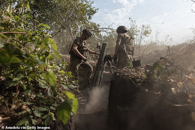 Ukrainian soldier in a mortar unit prepares to fire a rocket