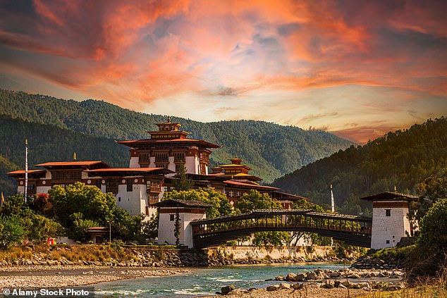 Beauty: Sara Wheeler travels through the Buddhist kingdom of Bhutan. Above, the sunset bathes the 'magnificent' Punakha Dzong fortress and the Mo Chhu River