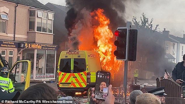 A police van is set on fire in Southport during the riots