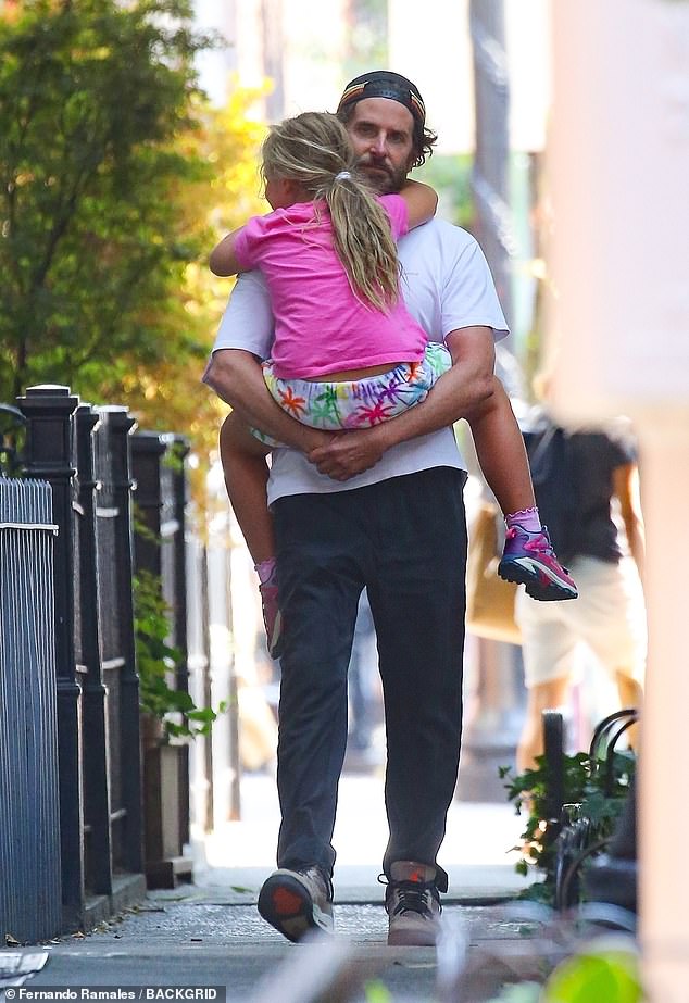 Bradley Cooper, 49, carried his daughter Lea, seven, in his arms during part of their walk together down a side street in New York City on Friday, September 13.