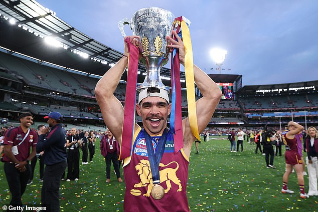 Charlie Cameron celebrates with the premiership trophy after the Swans' demolition in Brisbane, but he lost fans when he snubbed the youngster who put his grand final medal around his neck