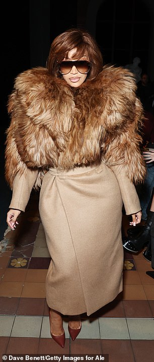 Cardi B stood out at McQueen's runway show wearing a short brunette wig and fur maxi coat as she was joined by Salma Hayek for the star-studded event on Saturday during Paris Fashion Week