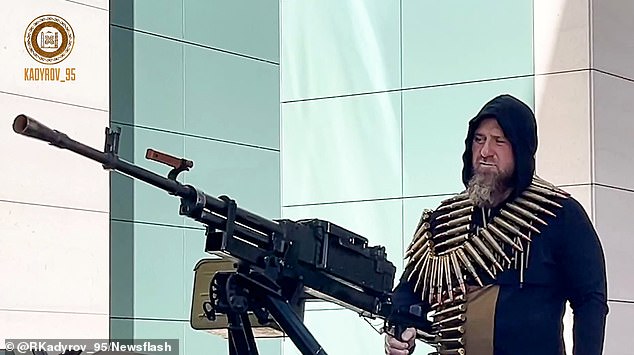 Kadyrov wears bullets around his neck as he poses with the machine gun atop his Tesla on August 17