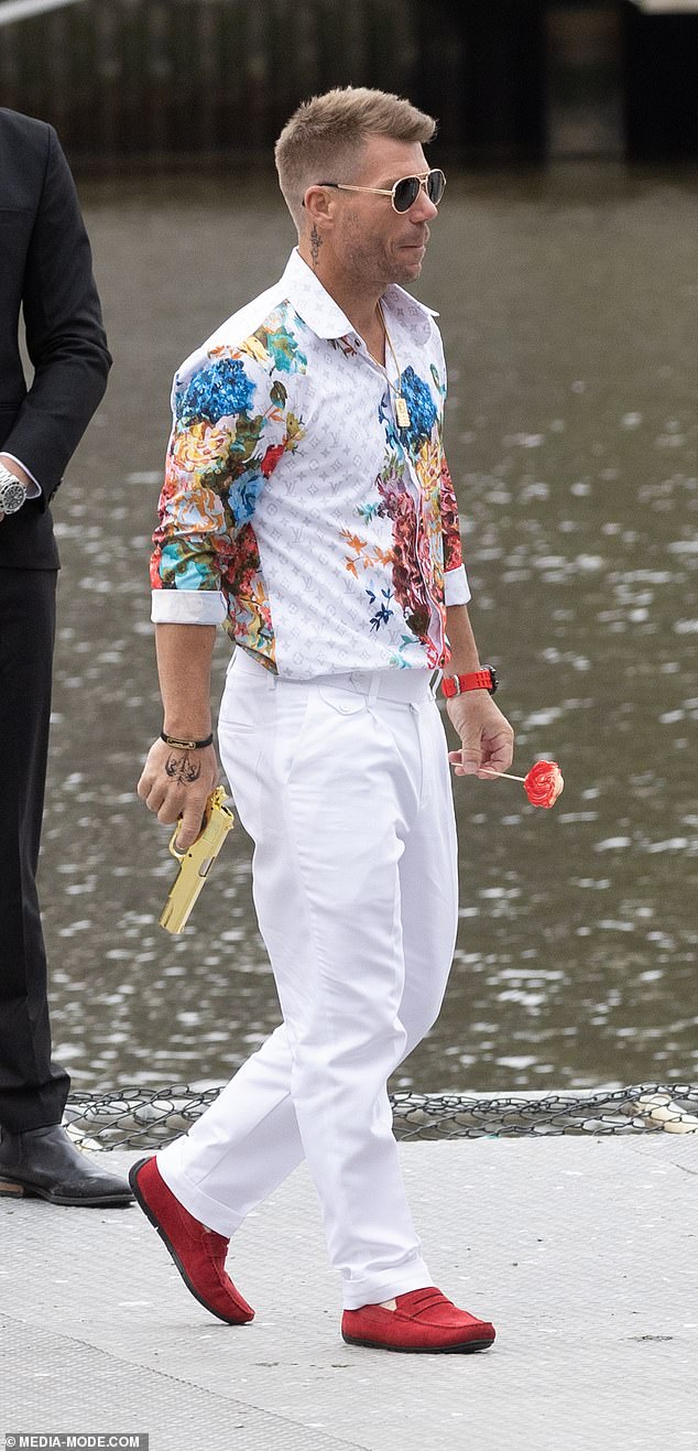 Cricket legend David Warner, 37, (pictured) put down the bat and picked up a rifle on a Melbourne helipad on Tuesday while filming an action scene on the Yarra River