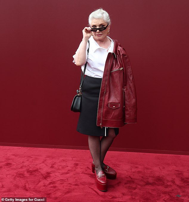 She added a pop of color to her outfit by posing in a red leather biker jacket