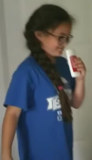 Above is a young girl sniffing a roll-on deodorant while trying to chrome