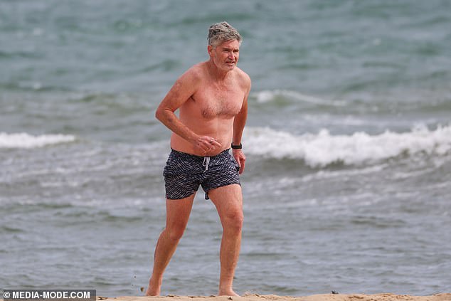 Dave 'Hughesy' Hughes braved the cold on Sunday as he headed to the beach with his family for Father's Day