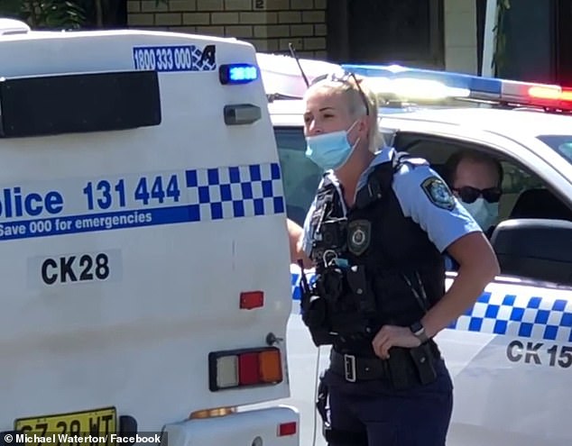 The sober officer stood next to a police car and silenced the difficult detainee