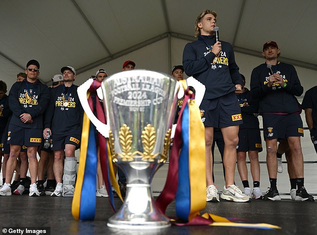 Brisbane Lions players celebrate their victory with their Melbourne Fitzroy supporters, who have remained loyal since the Bears merged with the Lions in 1996.