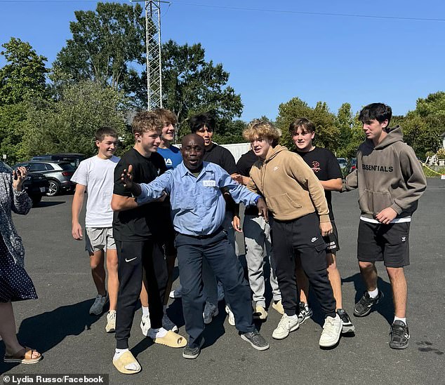 Francis Apraku, a janitor (center) at James Madison High School in Vienna, Virginia, was speechless after students rallied to give him a birthday present Monday