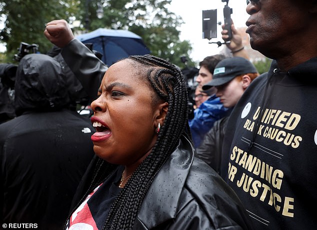 People protest as New York Mayor Eric Adams addresses the press outside his official residence Gracie Mansion on Thursday