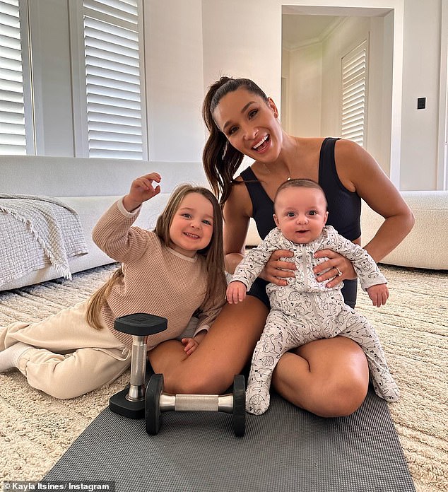 Kayla Itsines, 33, shared an adorable video of her daughter Arna, five, comforting her on Tuesday as she was bedridden with a stomach virus. Pictured: Kayla with her children Arna and Jax