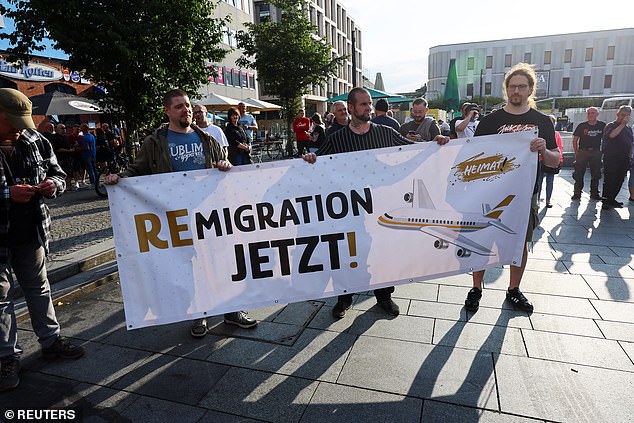 Far-right protesters hold a banner reading 