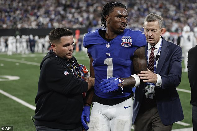 New York Giants wide receiver Malik Nabers (1) is helped off the field