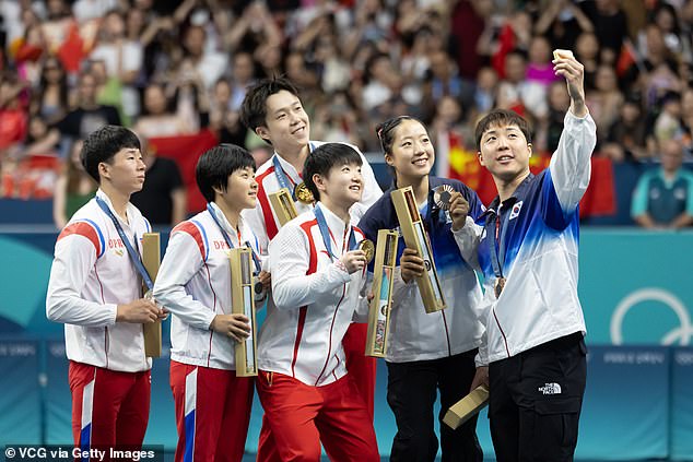 North Korean table tennis silver medalists Ri Jong-sik and Kim Kum-yong pose with South Korean bronze medalists Lim Jonghoon and Shin Yubin during the medal ceremony after the table tennis mixed doubles gold medal match on the fourth day of the Paris 2024 Olympic Games