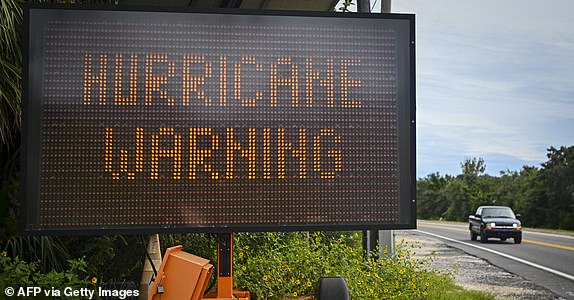 A hurricane warning sign stands on the side of a road as preparations are made for Hurricane Helene, in Cedar Key, Florida on September 25, 2024. Thousands of residents began evacuating parts of the Florida coast on Wednesday as the U.S. state braces for Hurricane Helene, which is expected to make landfall as a powerful, potentially deadly storm. Helene strengthened to a hurricane in the Gulf of Mexico by mid-morning and is "expected to bring life-threatening storm surges, damaging winds and flooding to much of Florida and the southeastern United States," the National Hurricane Center in Miami said in its latest bulletin. (Photo by Miguel J. Rodriguez Carrillo/AFP) (Photo by MIGUEL J. RODRIGUEZ CARRILLO/AFP via Getty Images)