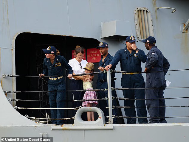 A woman and her daughter, stranded nearly 1,000 miles off the coast of Hawaii when Hurricane Gilma made landfall, embrace on the deck of the USS William P. Lawrence as the ship approaches Joint Base Pearl Harbor-Hickam in Honolulu on August 28, 2024.