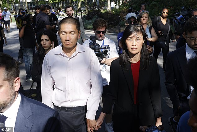 Linda Sun, a former aide to New York Gov. Kathy Hochul, and her husband Christopher Hu hold hands as they leave a Brooklyn courthouse after their arraignment on Tuesday. Sun is accused of being an aide to the Chinese government