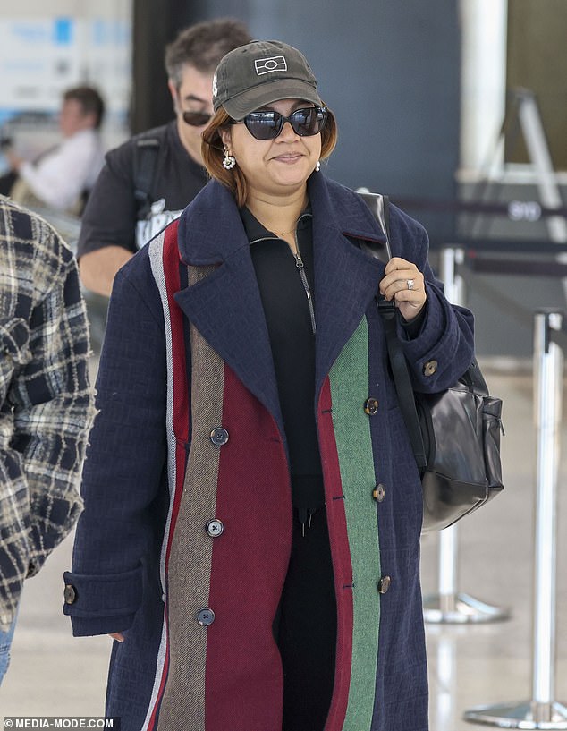 Jessica Mauboy (pictured) was spotted trying to hide her growing baby bump under a chunky patterned coat as she walked through Sydney Airport on Thursday