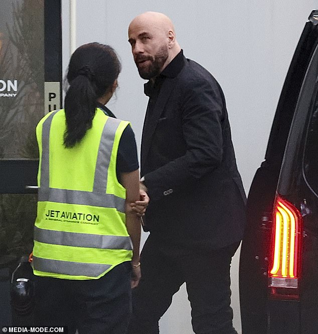 John Travolta kept a low profile as he arrived at Sydney airport with his family on Saturday to depart Australia