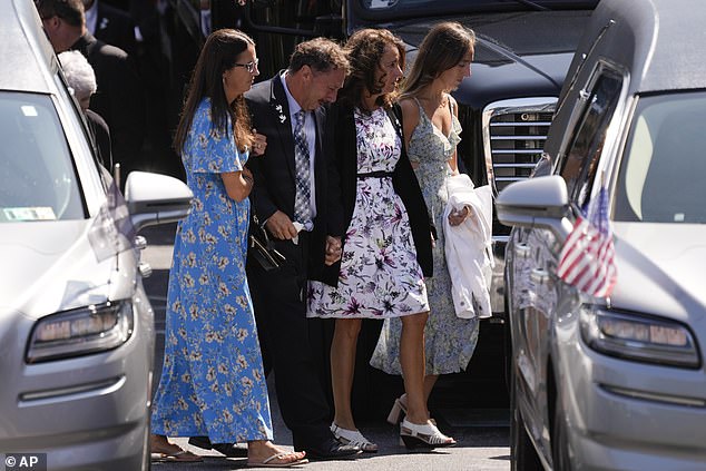 Family members are seen crying as they enter the church for the funeral