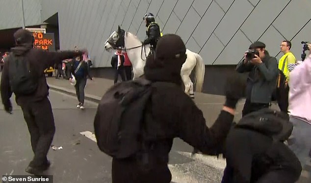 Anti-war protesters outside the Melbourne Convention and Exhibition Centre were filmed throwing horse dung at mounted police