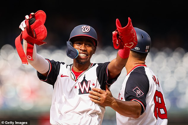 Washington Nationals' Darren Baker #10 celebrates with first base coach Gerardo Parra