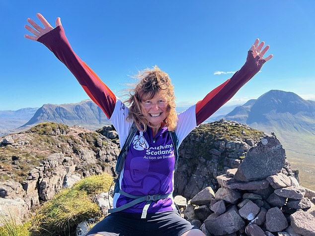 McCall celebrates her final climb to the top of Stac Pollaidh at the end of her challenge