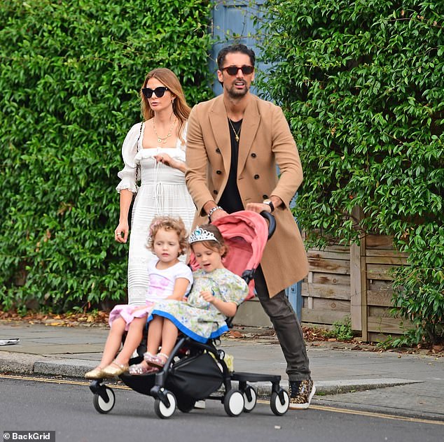 Millie Mackintosh exuded elegance in a white summer dress on Sunday as she enjoyed a leisurely stroll through London with her husband Hugo Taylor and their two daughters