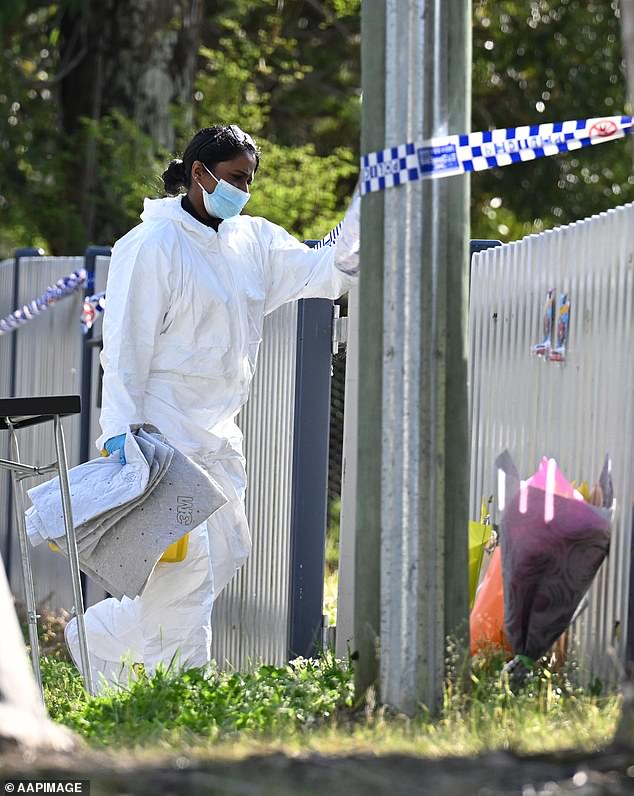 Police believe Russell and Ben may have been stabbed to death up to 17 hours before their bodies were found at their Faulconbridge home on September 10. A forensic officer examines floral tributes at the crime scene