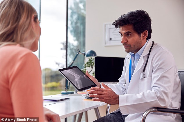 A GP with a patient (stock image). Although patient demand has increased by a third, figures show that GPs have reduced their contract hours by almost nine percent since 2015.