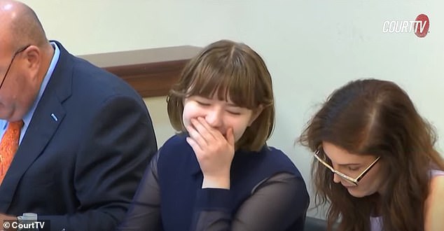 A teenage girl on trial accused of murdering her mother and attempting to murder her stepfather giggled and tried to cover her mouth as the fourth day of the trial began