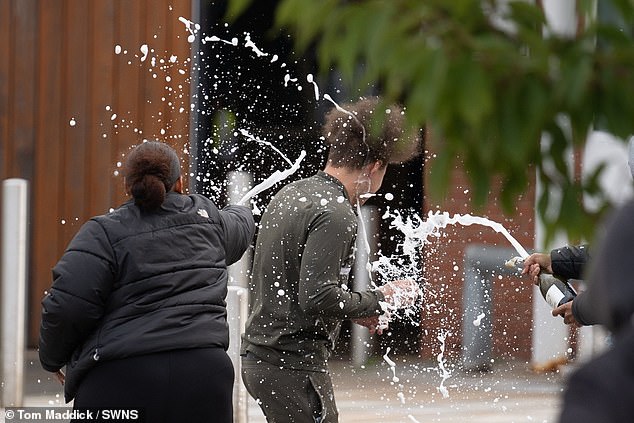 People spray a man with sparkling wine after he left HMP Nottingham following the government's controversial early release of prisoners