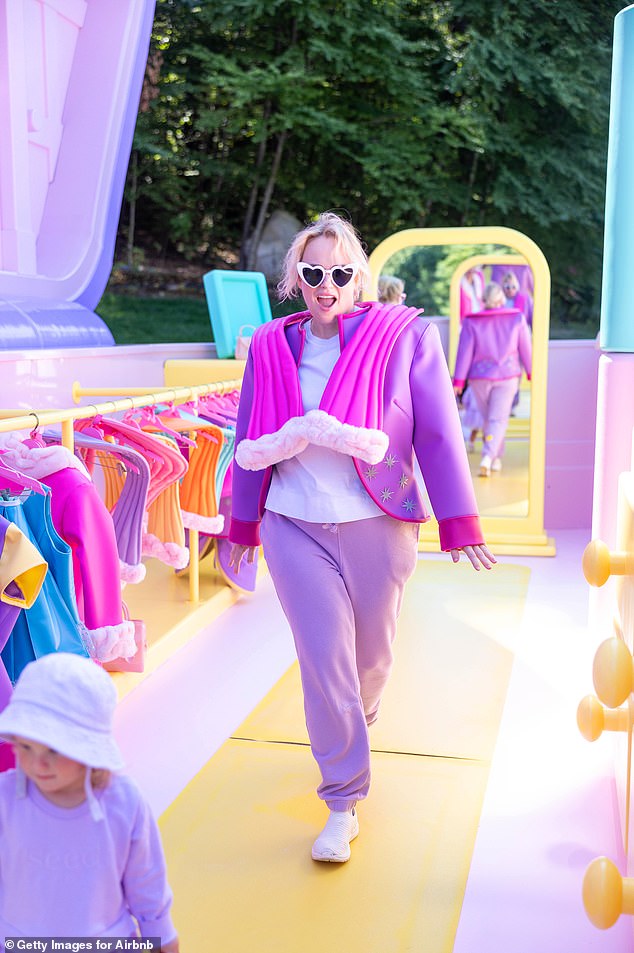 Rebel Wilson strutted her stuff on Polly Pocket's orange and purple runway, wearing an exact replica of the tiny doll's rubber outfit as her family visited the new Airbnb