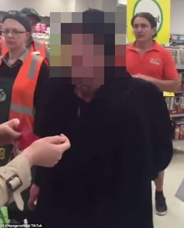 A customer started filming after a woman followed his group into a Woolworths store and cursed at them (aggressive woman is blurred)